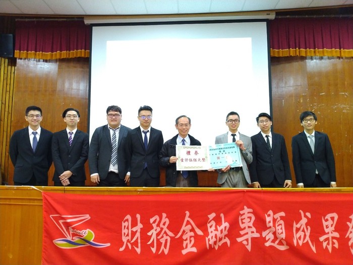 財金系姜清海主任頒發第1名獎狀並與第1組7位同學合照。